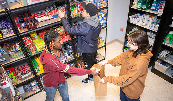 Three student workers assemble an order from the college’s Renzi Food Pantry.