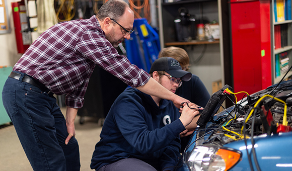 Brandon Baldwin instructs a student in the automotive lab.