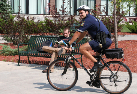 An officer rides a bicycle through the Roselle Plaza.