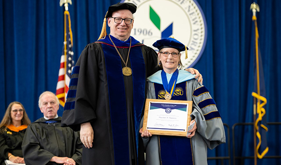 SUNY Canton President Zvi Szafran presents Maureen P. Maiocco, Ed.D., with the plaque denoting her SUNY Distinguished Teaching Professorship at the college’s Commencement.