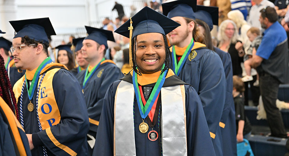 Graduate Calvin Reid smiles for during the Commencement procession.
