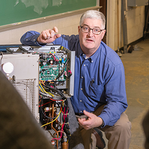 Dean Michael Newtown trains a class on heat pump mechanics.