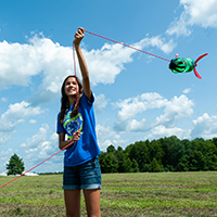 A student flies a bottle rocket on a string.