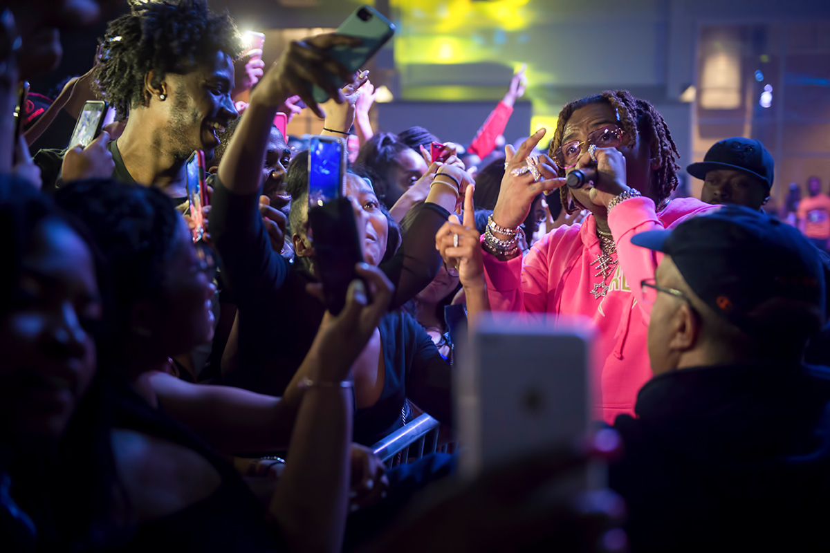 Gunna performs at Roos House while students snap photos.