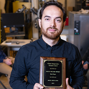 Aksel Seitllari holds a plaque recognizing the Virginia Transportation Research Council’s Jack H. Dillard Best Paper Award.