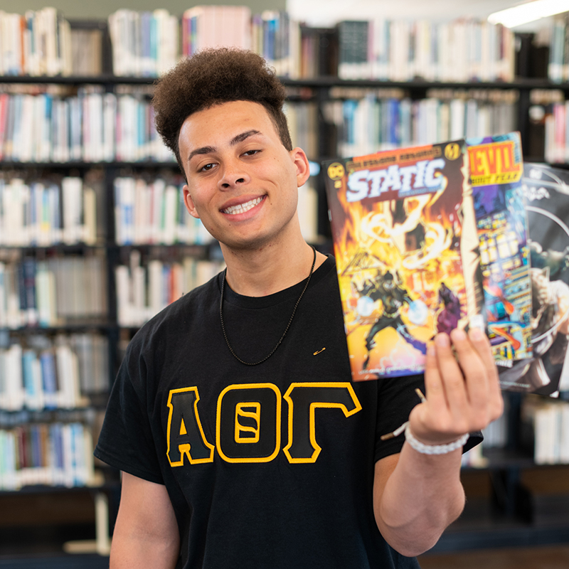 Anthony Probst holds up comic books