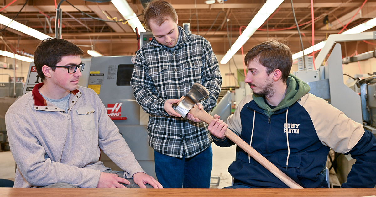 Nathan St. Louis, Matthew Gattus, and Mitch Timerman hold their finished axe.