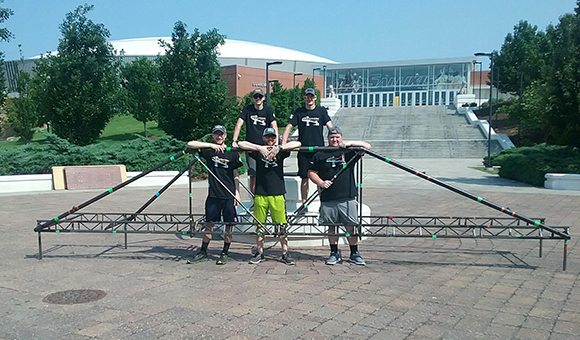The SUNY Canton Steel Bridge Team stands with their bridge in front of Southern Illinois University, Carbondale.