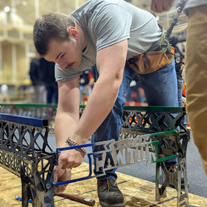 George Staats assembles the college’s steel bridge for aesthetics judging.