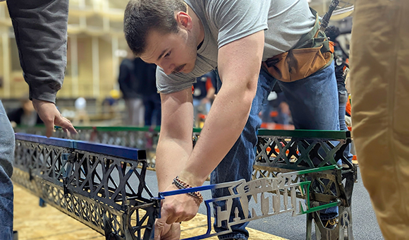 George Staats assembles the college’s steel bridge for aesthetics judging.