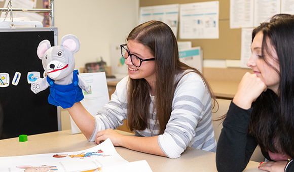 Students use a puppet in the Early Childhood Studies lab.