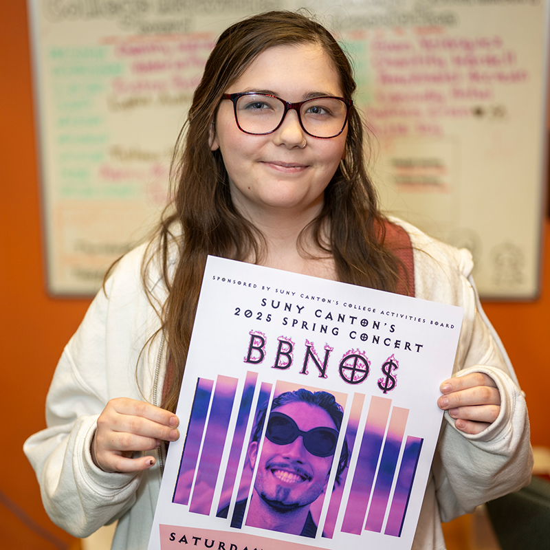 Chastity Wardell holds a bbno$ concert poster.