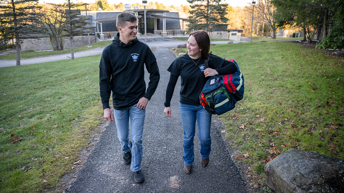 Gage Halavin and Alivia Gilson walk to the Richard W. Miller Campus Center with their EMS gear.