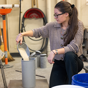 Emma Kielmeier pours material into a cylinder cast.