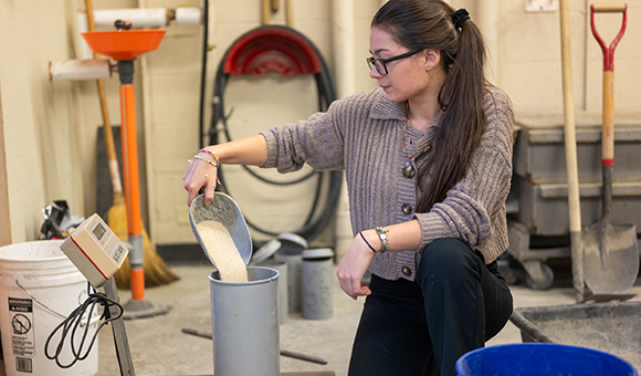Emma Kielmeier pours material into a cylinder cast.