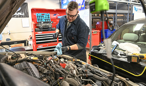 Eric Armstrong checks fluid levels in the Automotive Lab.