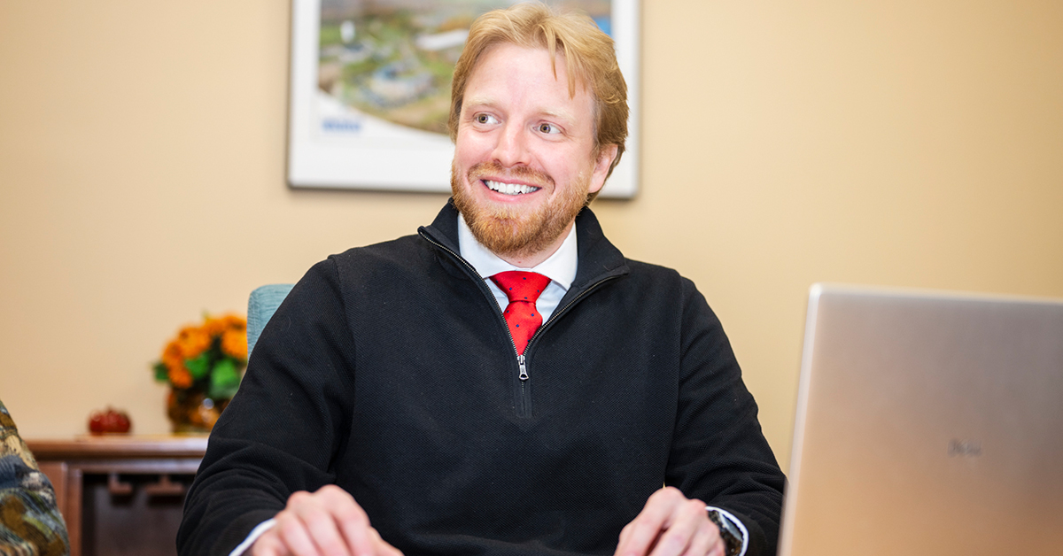 Eric Shinnick smiles while sitting at a desk.