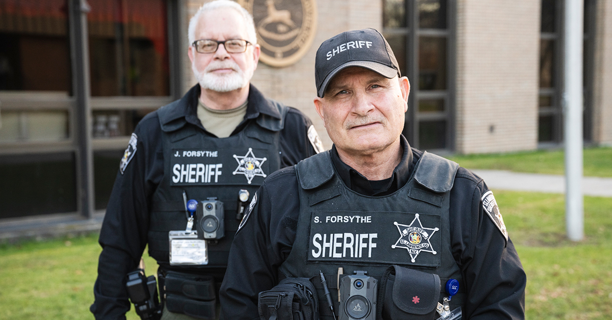 Jeffrey and Steven Forsythe stand outside the St. Lawrence County building in uniform.