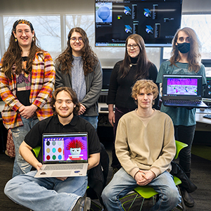 Members of the Game Design Club pose with laptops displaying their newest game, "Physhbowl."