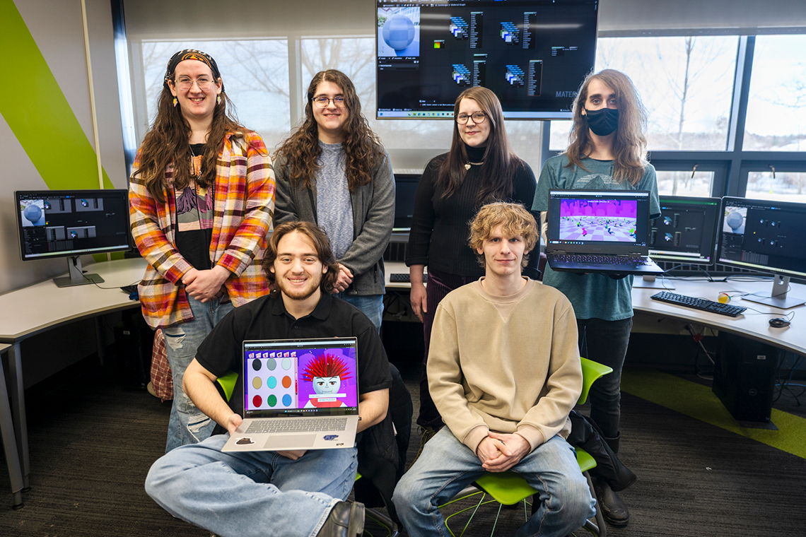 Members of the Game Design Club pose with laptops displaying their newest game, 