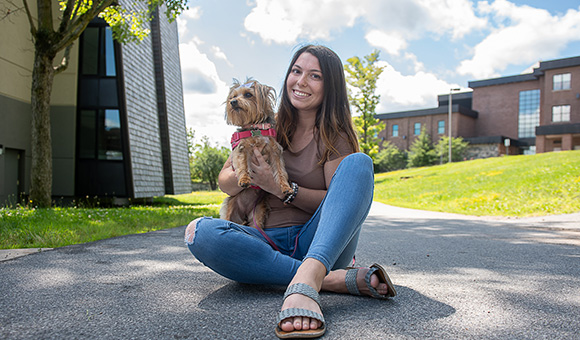 Hannah Froedtert and her pet dog, Maggie, sit outside Rushton Hall.