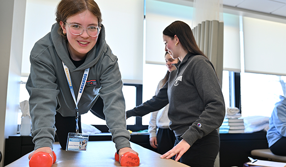 A student participates in a Physical Therapist Assistant exercise demo.