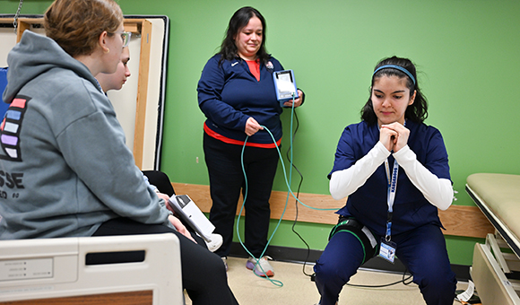 Associate Professor Jane Parcell assists MASH students with a blood-flow restriction exercise.