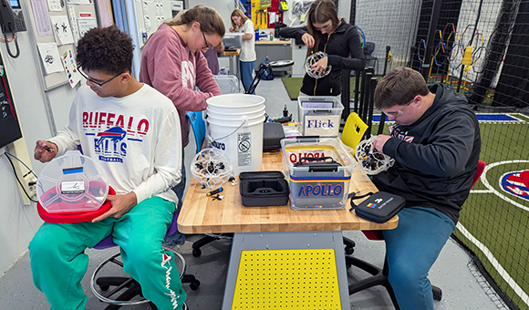 Madrid-Waddington students building and repairing drones in a technology classroom.