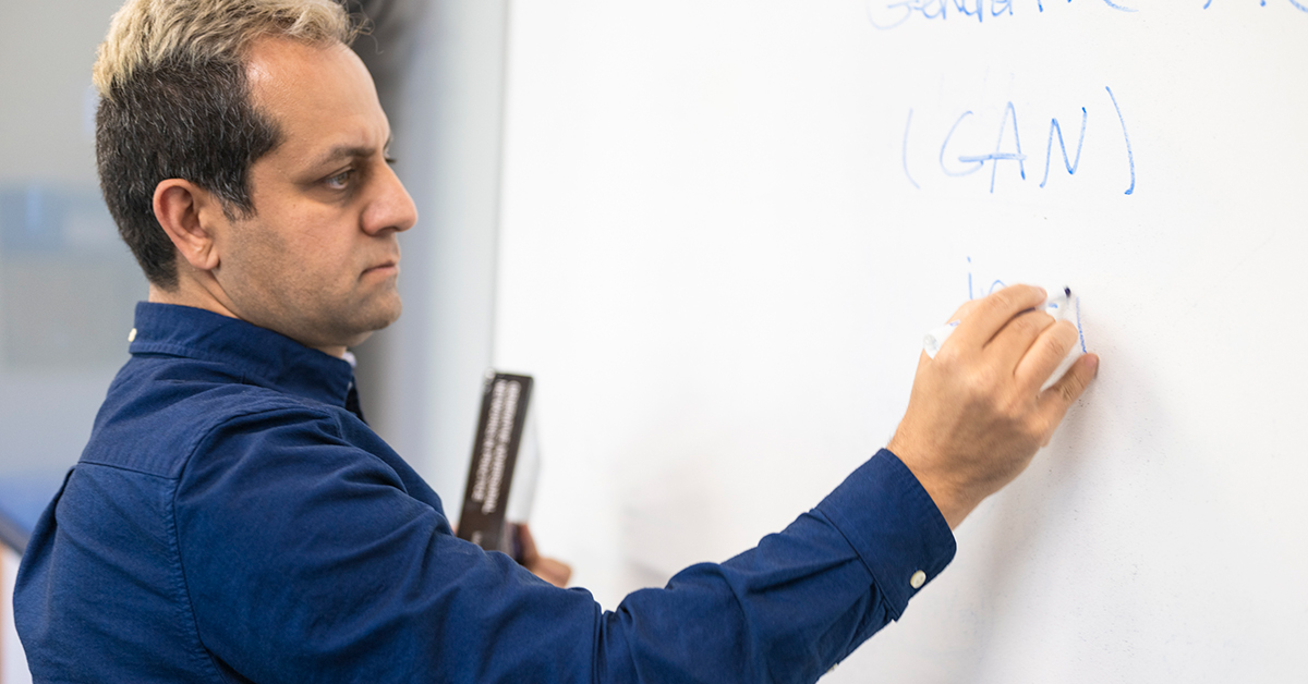 Mehdi Ghayoumi writes on a marker board.