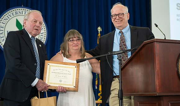 Pam Sheldon is awarded by Ronald O'Neill and President Szafran.