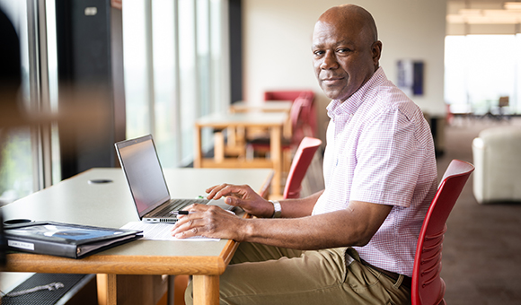 Phillip James works on a laptop in Southworth Library.