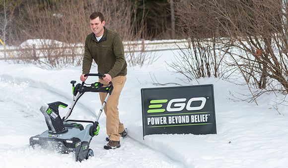 Johnathan Pinckney uses an ECO snowblower to remove snow from a driveway.