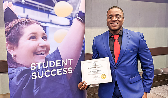 Samuel Diffo holds his Chancellor's Award certificate