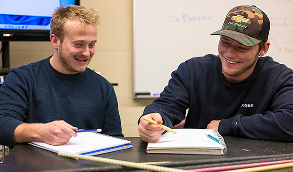 Two students work on their Glass Fiber Reinforced Polymer (GFRP) poster presentation.