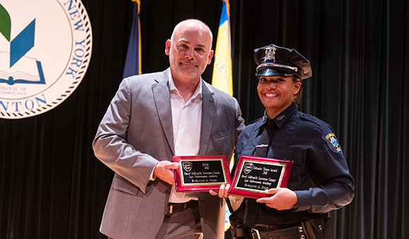 Director Joseph W. Brown presents Breanne A. Sapp with awards at the 25th annual academy graduation ceremony.