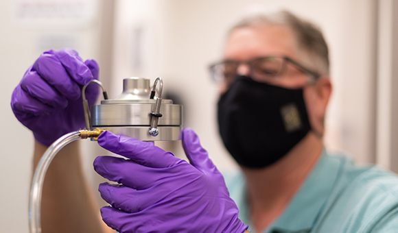 Dean Michael Newtown sets up an air quality test in the Davis Health Center.