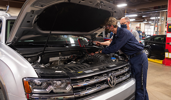 Associate Professor Brandon J. Baldwin assisting Automotive Technology student Keyan L. Deom.