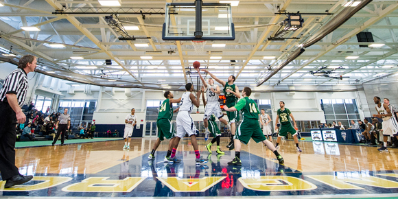 A men's basketball player drives to the hole for a score