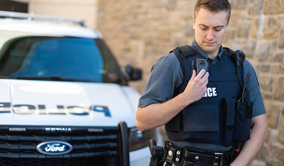 A university police officer activates his body camera. 