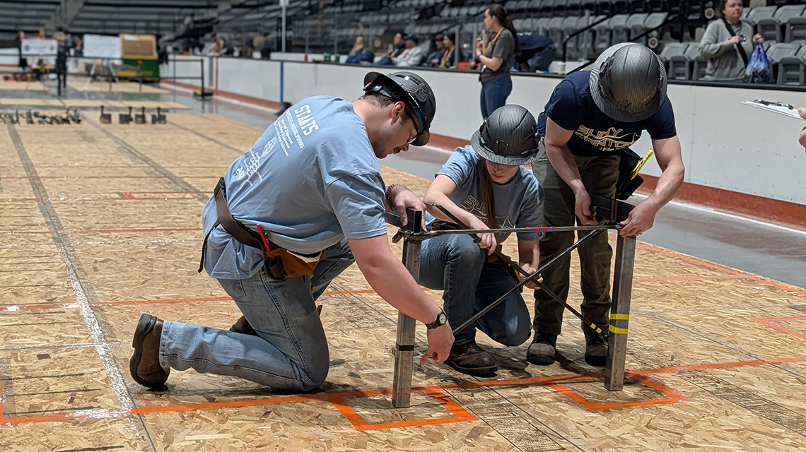 George Staats, Ciara McDougal and Ryan Willard assemble a portion of the college’s bridge.