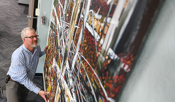 Matthew Burnett hangs one of his painting featured in his 