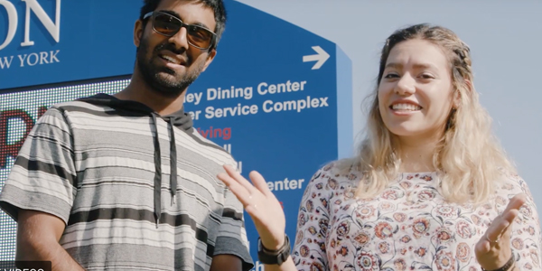 Gokul and Jade in front of the digital sign