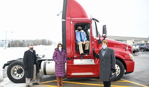 Patrick Kelly, Rebecca Blackmon, President Zvi Szafran and Provost Peggy DeCooke pose in front of the College's new red truck for CDL training.