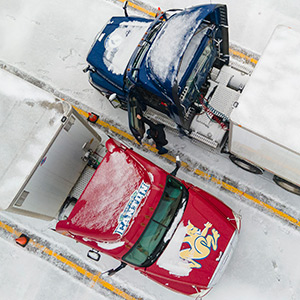 An overhead view of a red and blue truck parked diagonally in the snow.