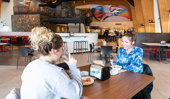 Two students dine at at table in Chaney Dining Center.