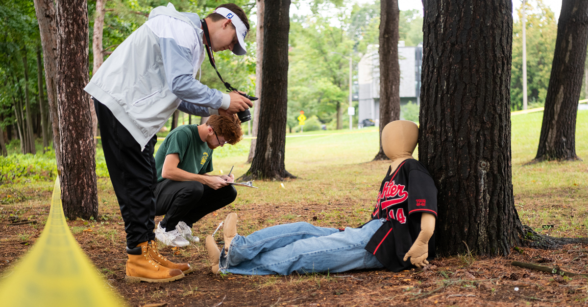 Two students inspect a mock crime scene.