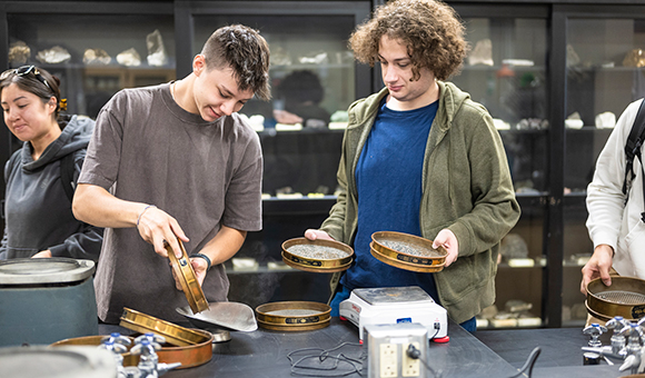 Two students sift through sediment in the water filtration lab.