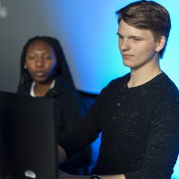 Two students work on a computer in the Cybersecurity lab.