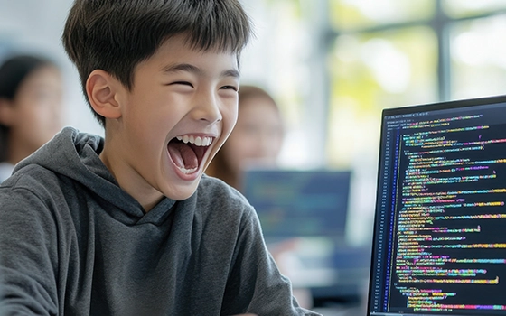 An excited camper codes on a computer.