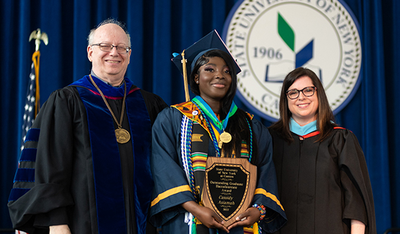 Cassidy Asiamah receives the Outstanding Graduate Award from President Szafran and Vice President Courtney Bish.